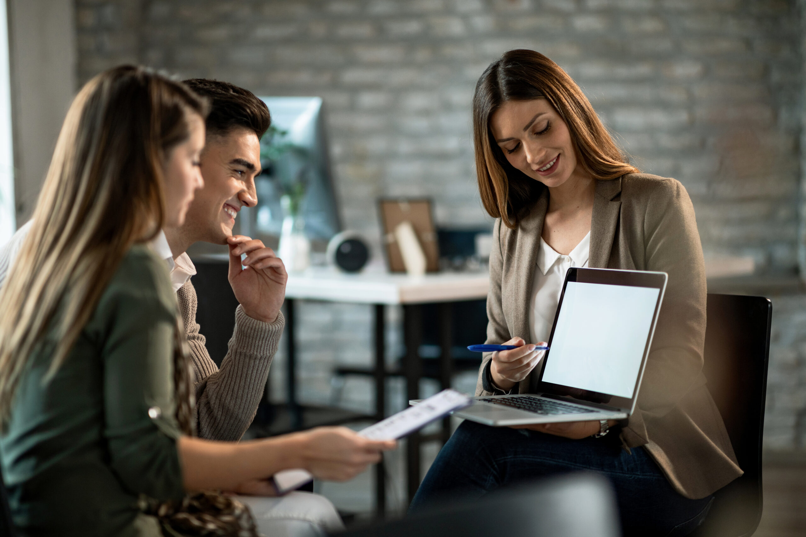 happy-couple-and-their-insurance-agent-using-lapto-2023-11-27-05-28-58-utc-scaled.jpg